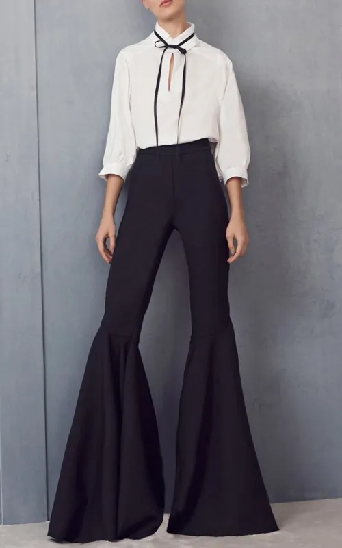 Set đồ phối quần ống loe tối màu cùng tone áo trắng có nơ buộc cổ giúp giấu nhẹm khuyết điểm cơ thể của bạn mông to nên mặc chân váy gì